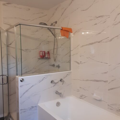 Reversible tub to shower conversion with low step entry for mobility friendly bathroom accessibility.