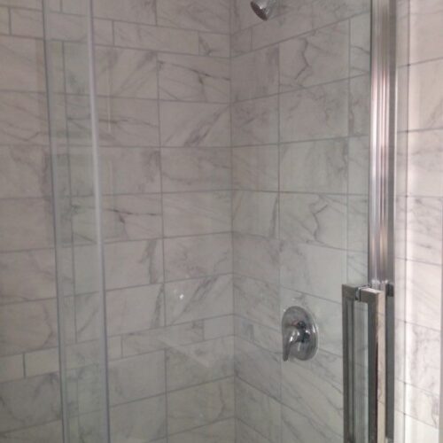 Reversible tub to shower conversion with low step entry for mobility friendly bathroom accessibility.